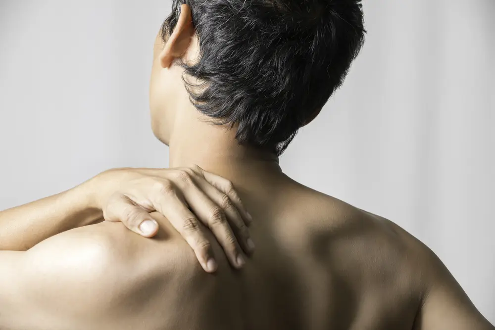 Man holding shoulder due to shoulder pain 