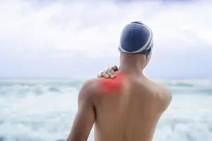 man with shoulder pain before swimming