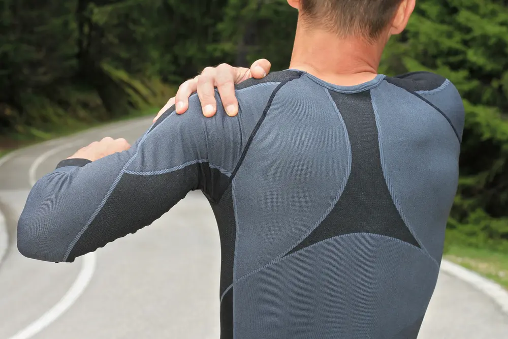 Man touching shoulder after exercising